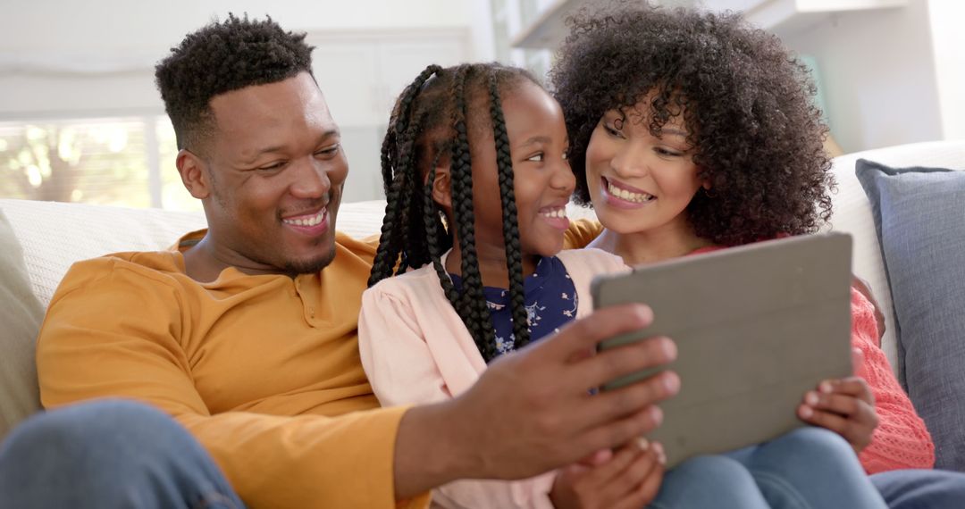 Happy African American Family Using Tablet on Couch - Free Images, Stock Photos and Pictures on Pikwizard.com