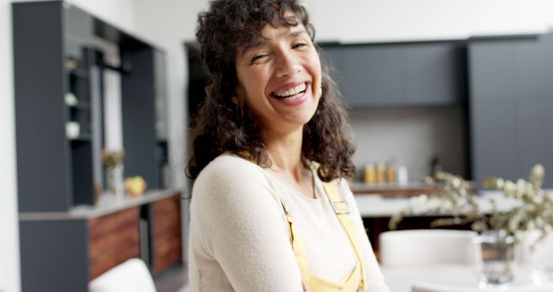 Smiling Woman in Modern Kitchen with Yellow Overalls - Free Images, Stock Photos and Pictures on Pikwizard.com