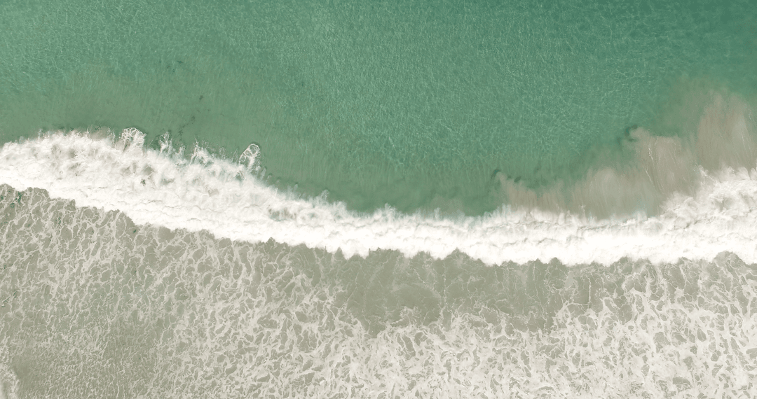 Transparent Turquoise Waves Crashing Onto Seashore
