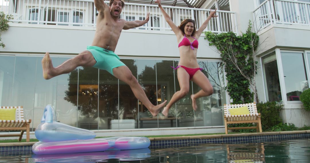 Couple Jumping into Pool in Swimwear, Showing Enthusiastic Fun - Free Images, Stock Photos and Pictures on Pikwizard.com