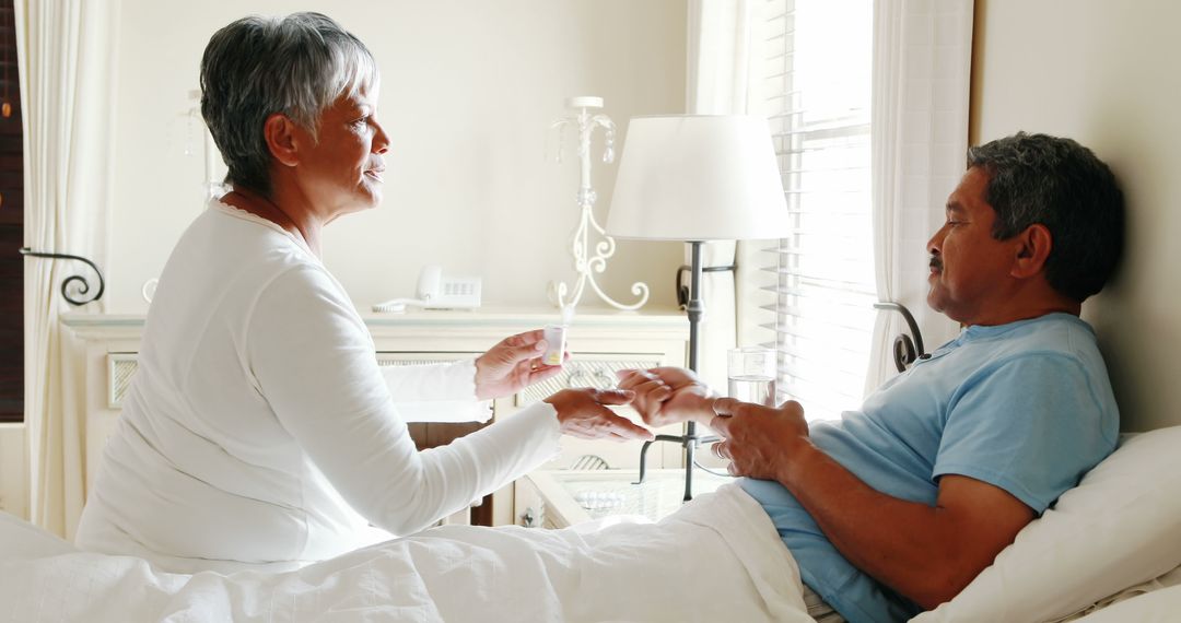 A woman provides comforting bedside support to a patient in a caring environment. - Free Images, Stock Photos and Pictures on Pikwizard.com