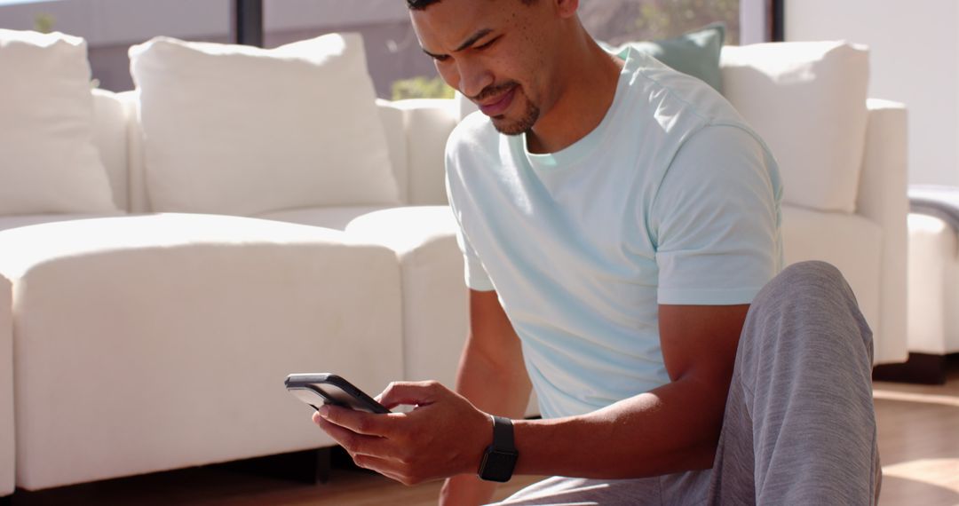 Man Relaxing at Home Browsing Smartphone in Modern Living Room