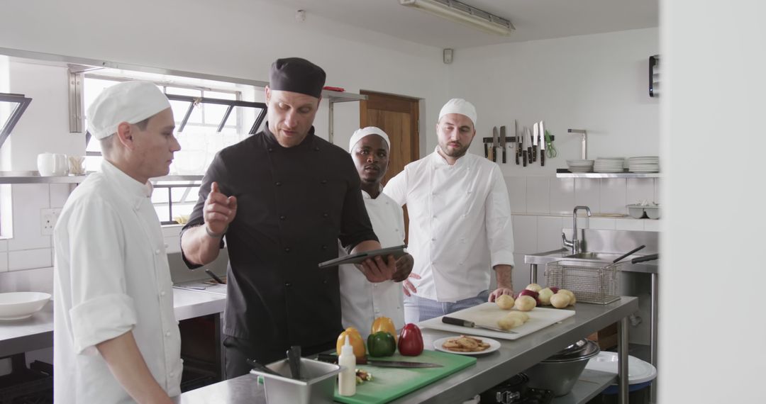 Head Chef Discussing Recipe with Team in Professional Kitchen - Free Images, Stock Photos and Pictures on Pikwizard.com