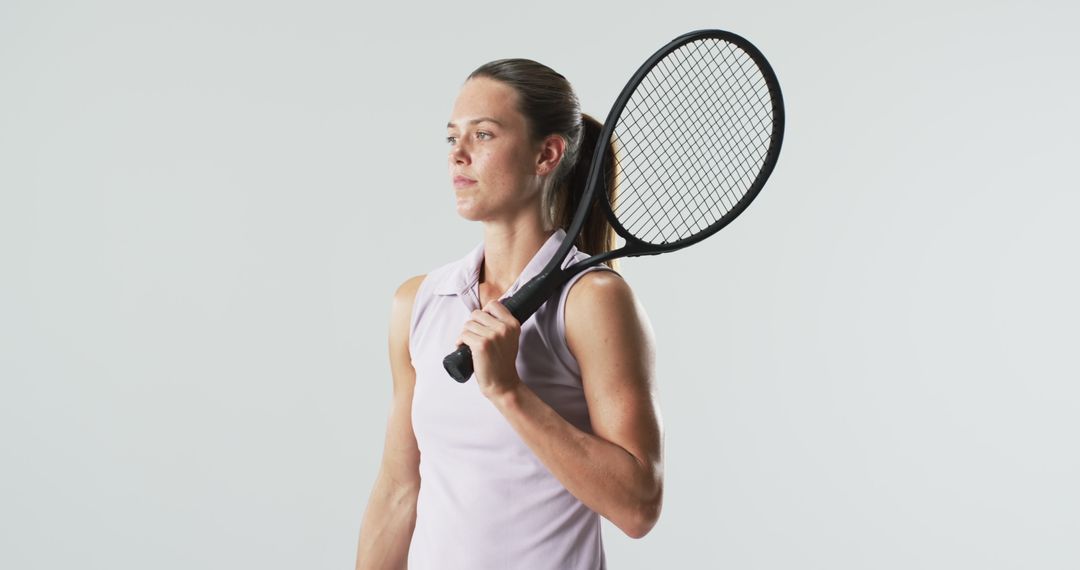 Confident Female Tennis Player Posing with Racket Embracing Determination