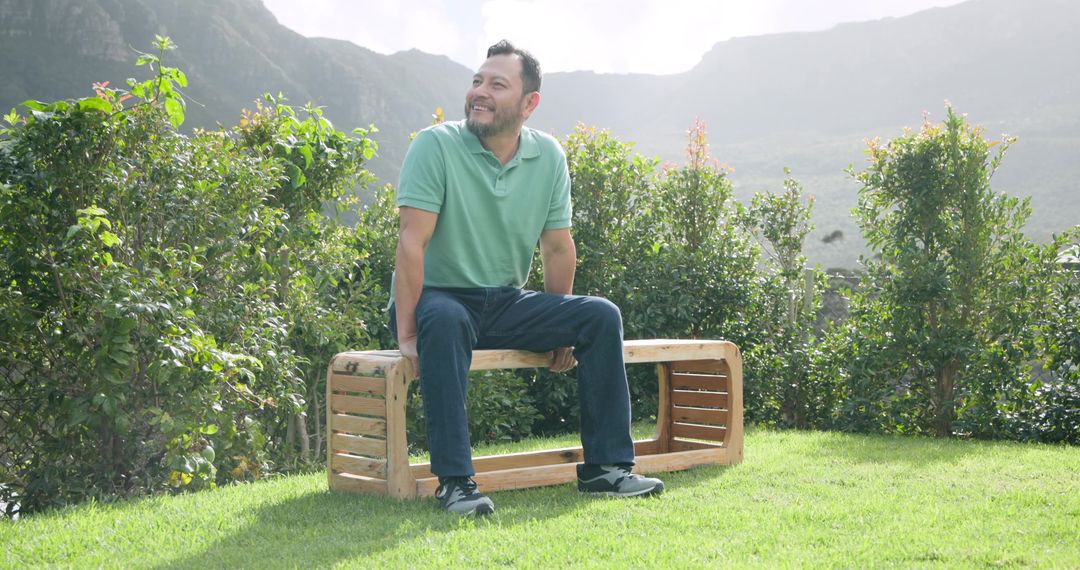 Man Enjoying Nature on Wooden Bench in Scenic Mountain Park