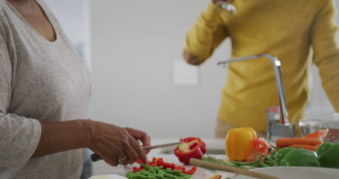 Elderly Woman Preparing Vegetables for Healthy Meal while Drinking Smoothie - Free Images, Stock Photos and Pictures on Pikwizard.com