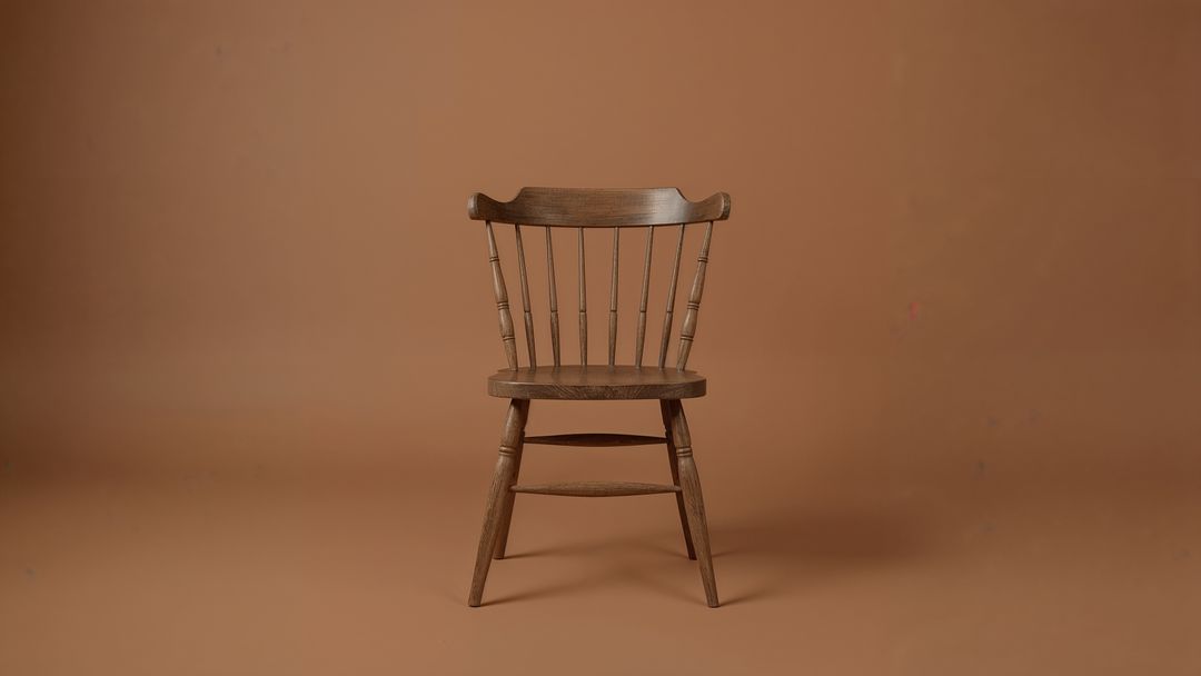 Rustic Wooden Chair with Spindle Back on Brown Backdrop