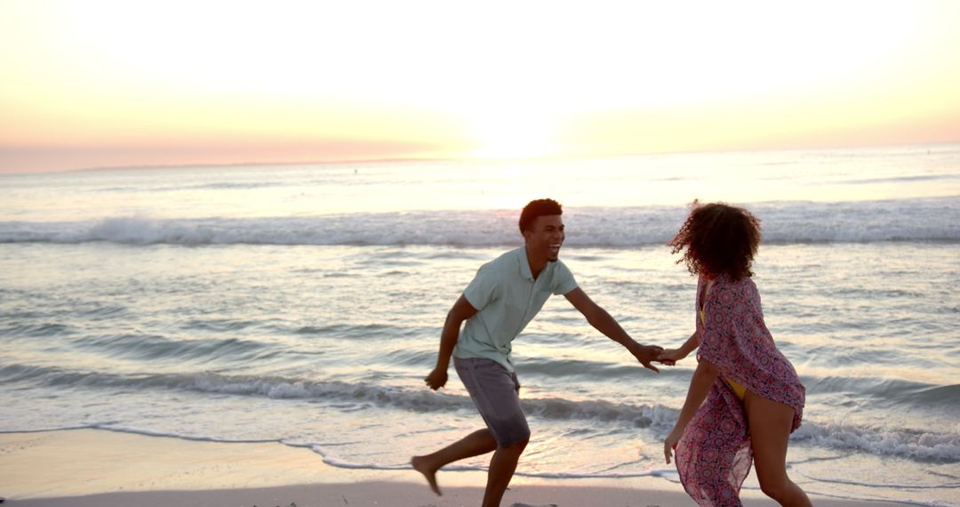 Romantic Beach Sunset Embrace: Couple Running Playfully by Ocean Waves