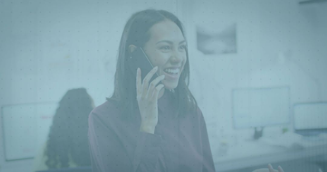 Smiling Asian Woman on Smartphone in Modern Workspace