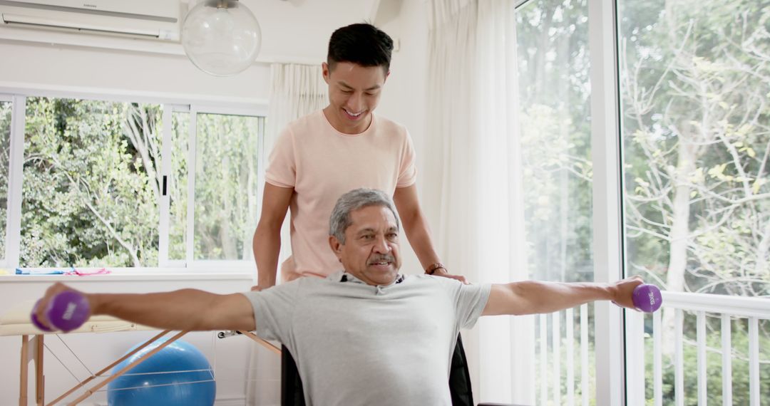 Elderly Man Exercising with Dumbbells Receiving Assistance from Young Trainer - Free Images, Stock Photos and Pictures on Pikwizard.com