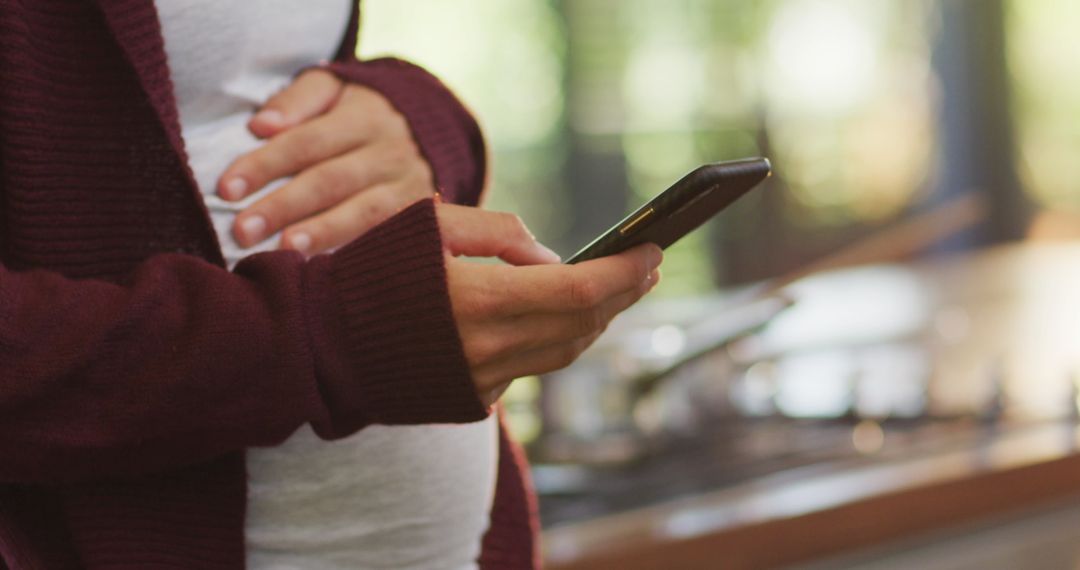 Pregnant Woman Using Smartphone in Home Setting