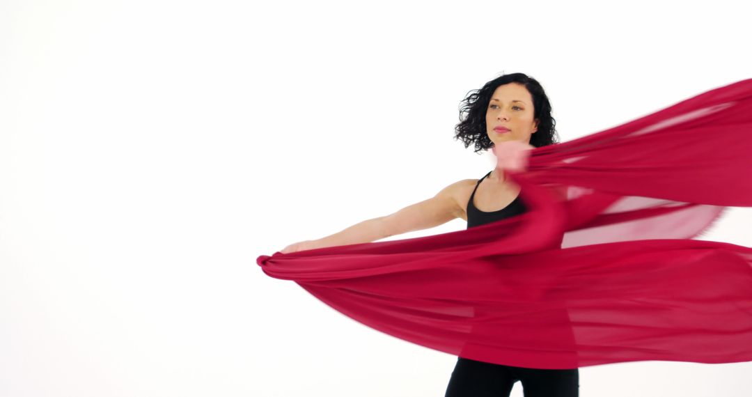 Graceful Woman Dancing with Flowing Red Fabric