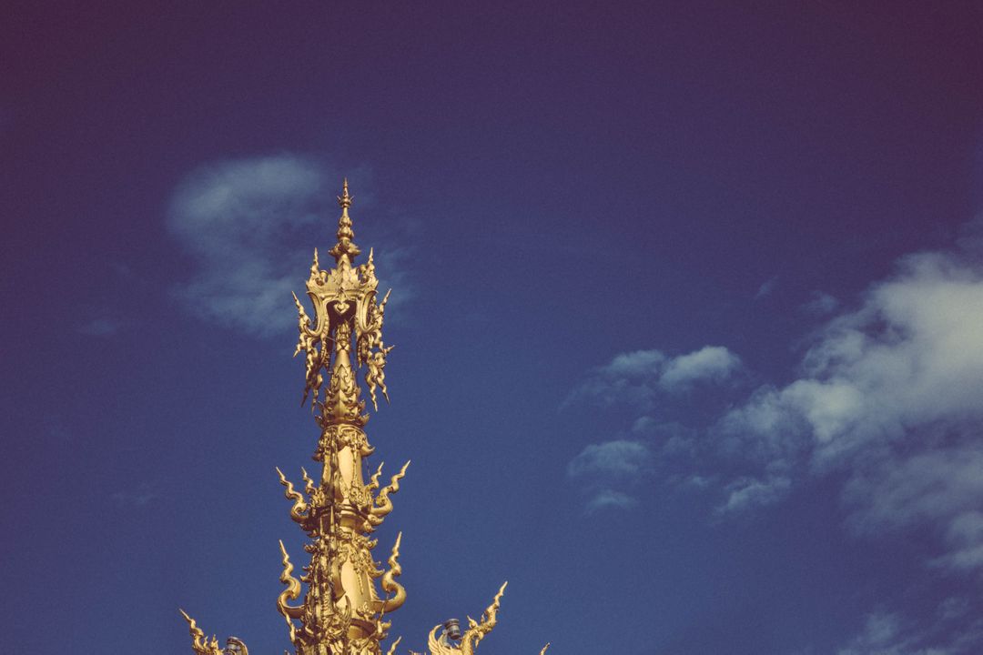 Intricate Golden Temple Spire Against Clear Blue Sky - Free Images, Stock Photos and Pictures on Pikwizard.com