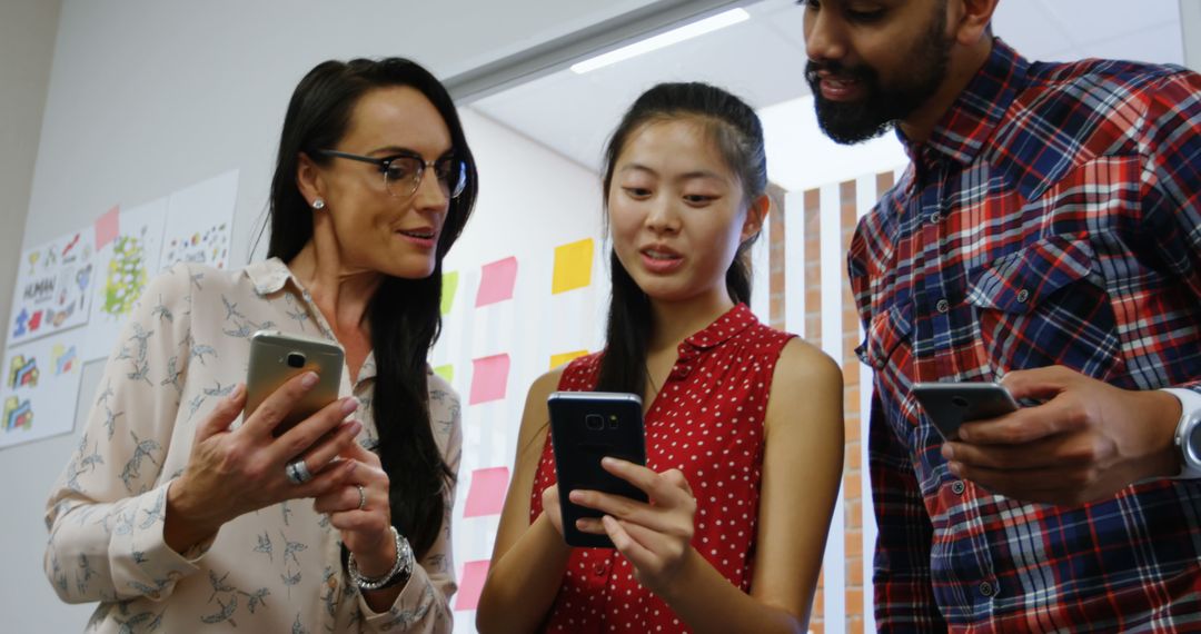 Diverse Professionals Collaborating on Mobile Devices in Office