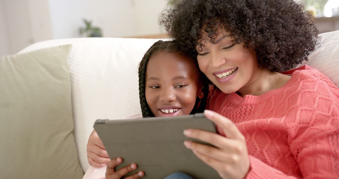 Mother and Daughter Smiling While Using Digital Tablet at Home - Free Images, Stock Photos and Pictures on Pikwizard.com