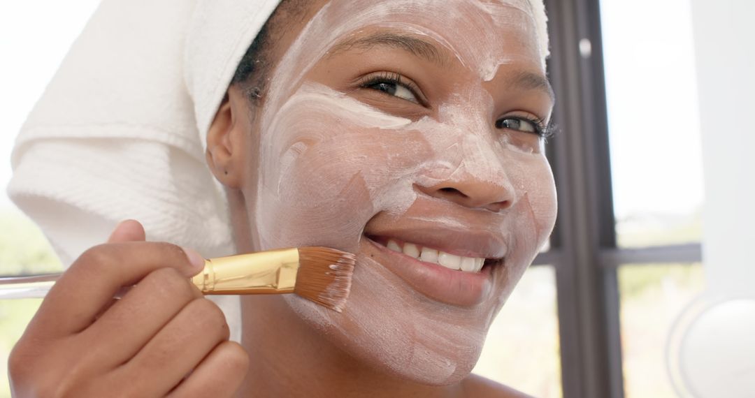 Smiling Woman Applying Facial Mask with Brush in Spa - Free Images, Stock Photos and Pictures on Pikwizard.com