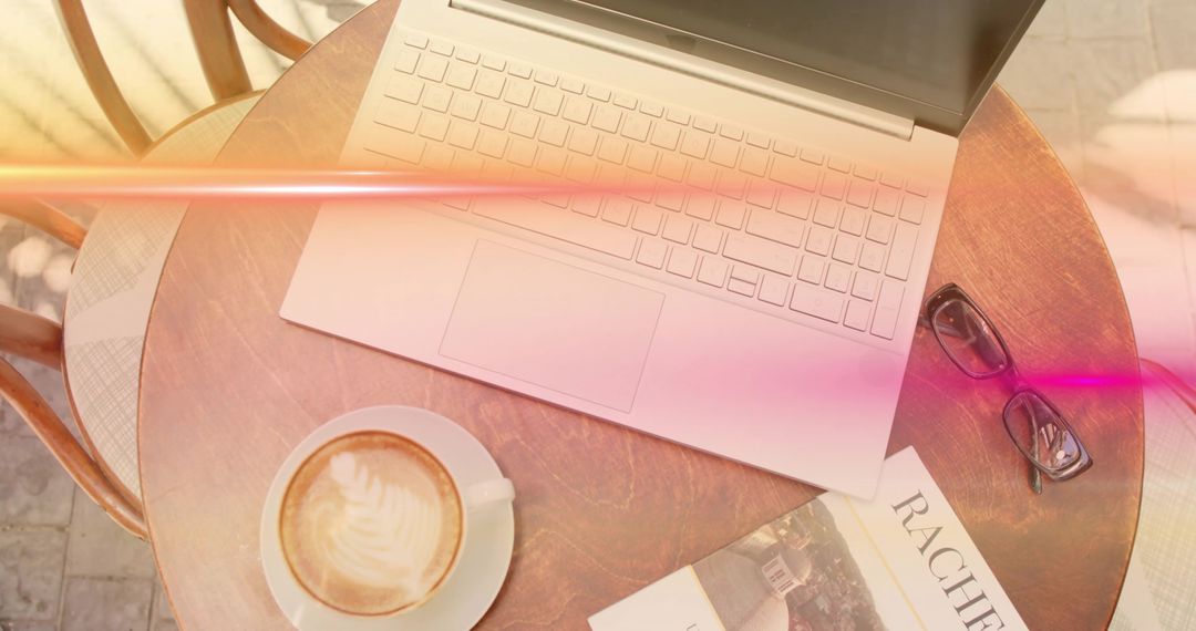 Laptop Outside Cafe with Coffee and Book in Sunlight