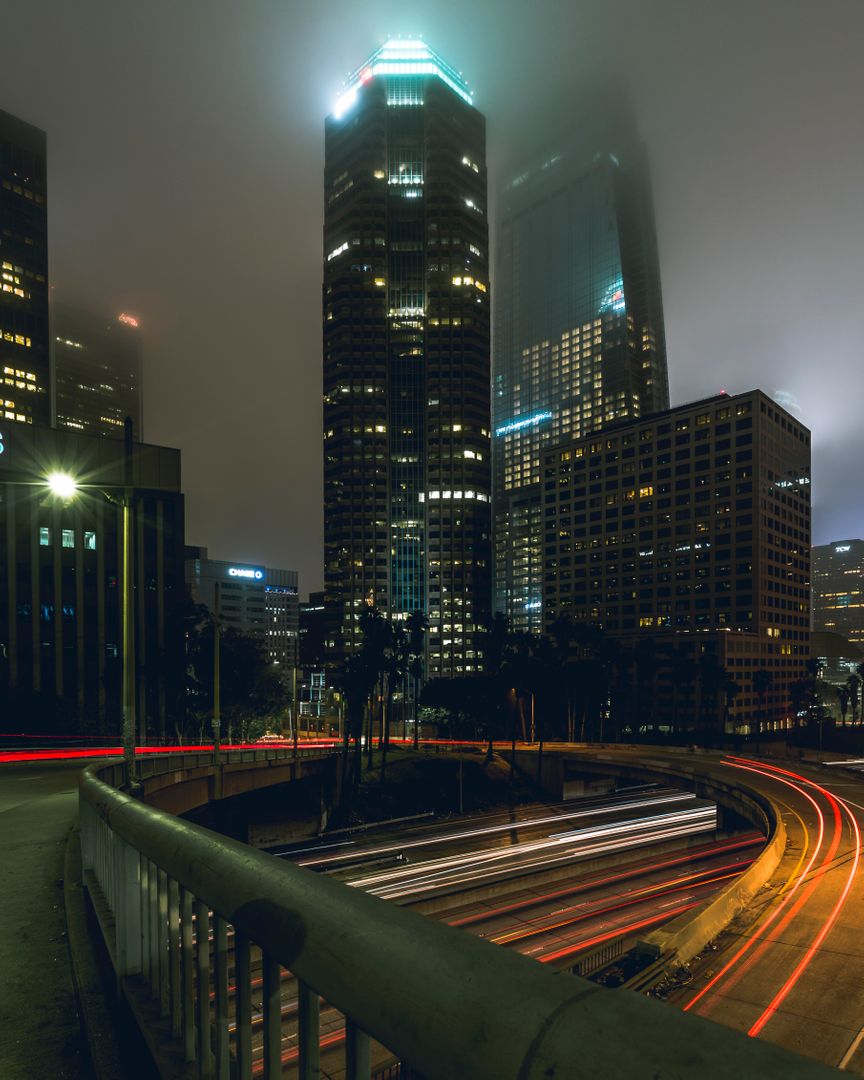 Foggy Night City Skyline with Light Trails on Highway - Free Images, Stock Photos and Pictures on Pikwizard.com