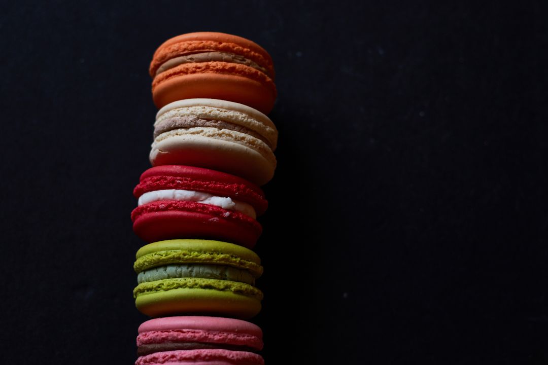 Vibrant Macarons Stacked Against Dark Background