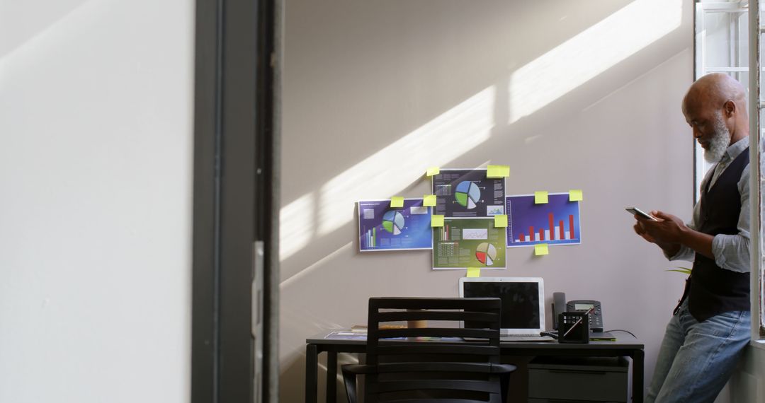 Businessman Analyzing Data Charts on Wall in Office - Free Images, Stock Photos and Pictures on Pikwizard.com