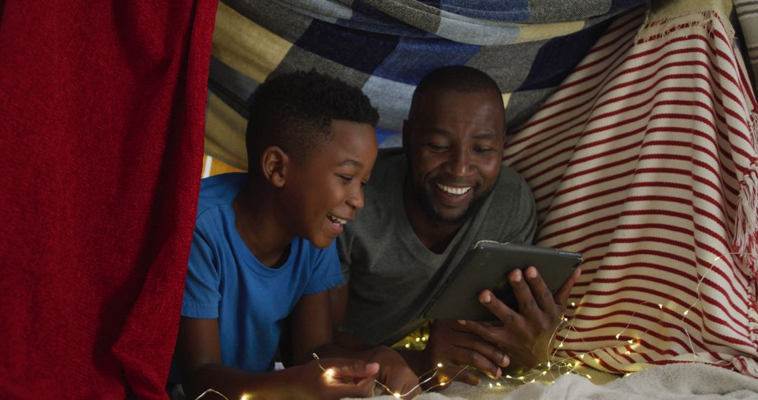 Father and Son Enjoying Movie in Blanket Fort with Tablet - Free Images, Stock Photos and Pictures on Pikwizard.com