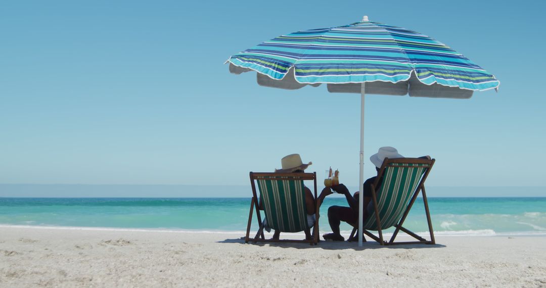 Couple Relaxing Under Umbrella on Tropical Beach - Free Images, Stock Photos and Pictures on Pikwizard.com