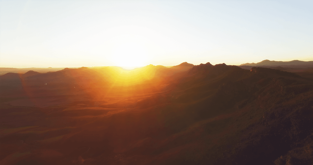 Transparent Sun Setting Over Mountainous Horizon Capturing Scenic Beauty