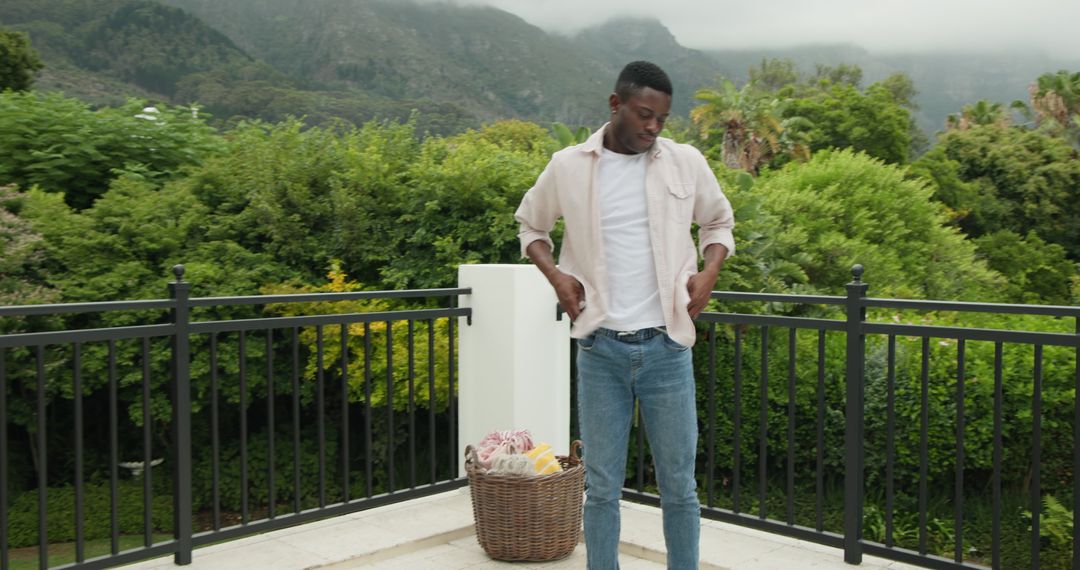 Man preparing cozy outdoor patio for picnic