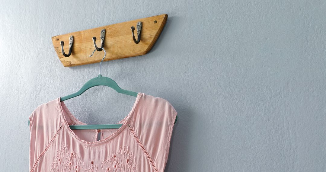 Pink Blouse on Wooden Hanger Hooked on Rustic Wall Hook - Free Images, Stock Photos and Pictures on Pikwizard.com