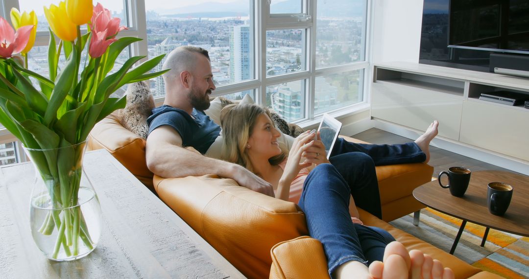 Couple Relaxing on Sofa Enjoying Digital Entertainment in Modern City Apartment