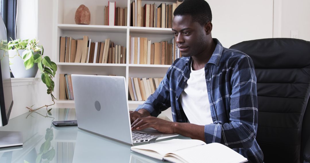 Focused Professional Typing on Laptop in Home Office Setup
