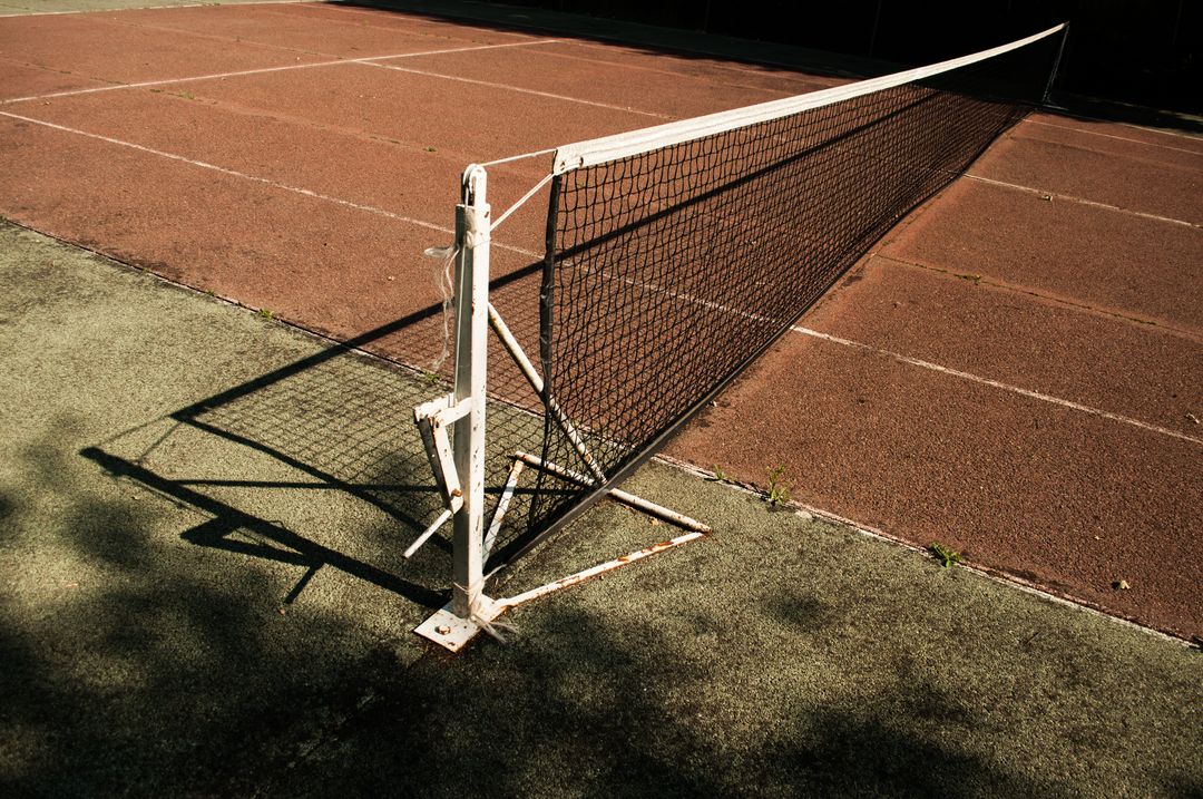 Empty tennis court with a net on a sunny day - Free Images, Stock Photos and Pictures on Pikwizard.com