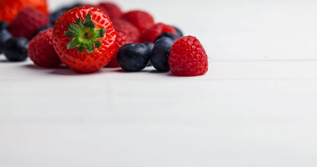 Berry Medley on White Surface with Ample Copy Space