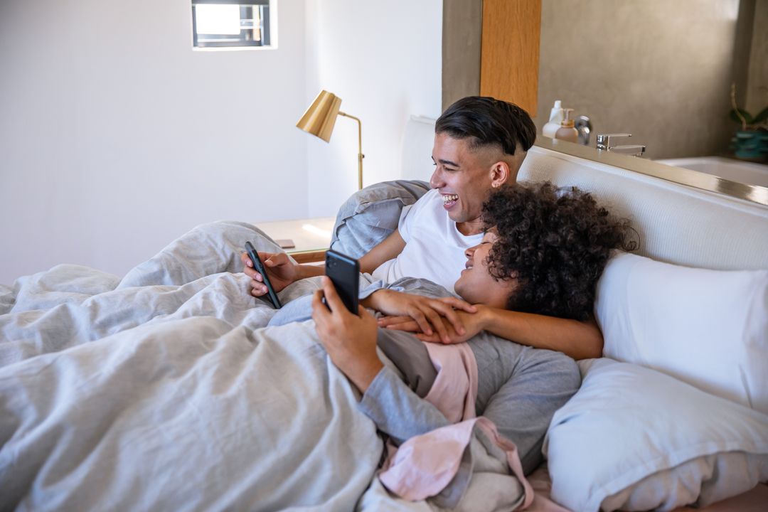 Couple Relaxing in Bed While Using Smartphones