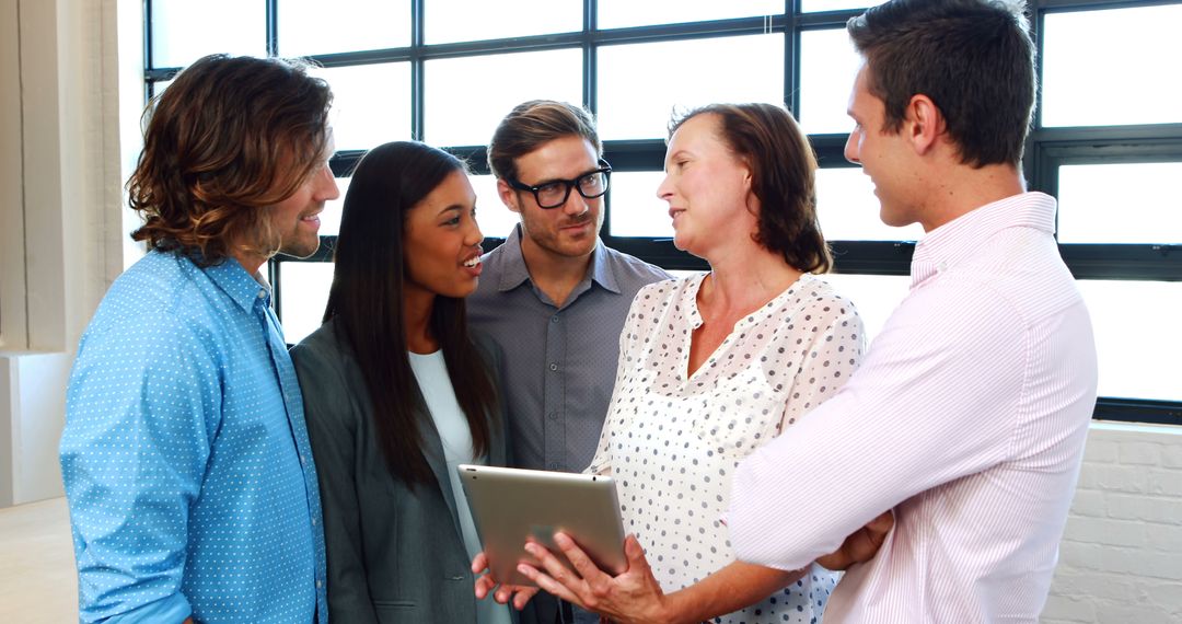Team Collaborating Over Digital Tablet in Bright Office Space