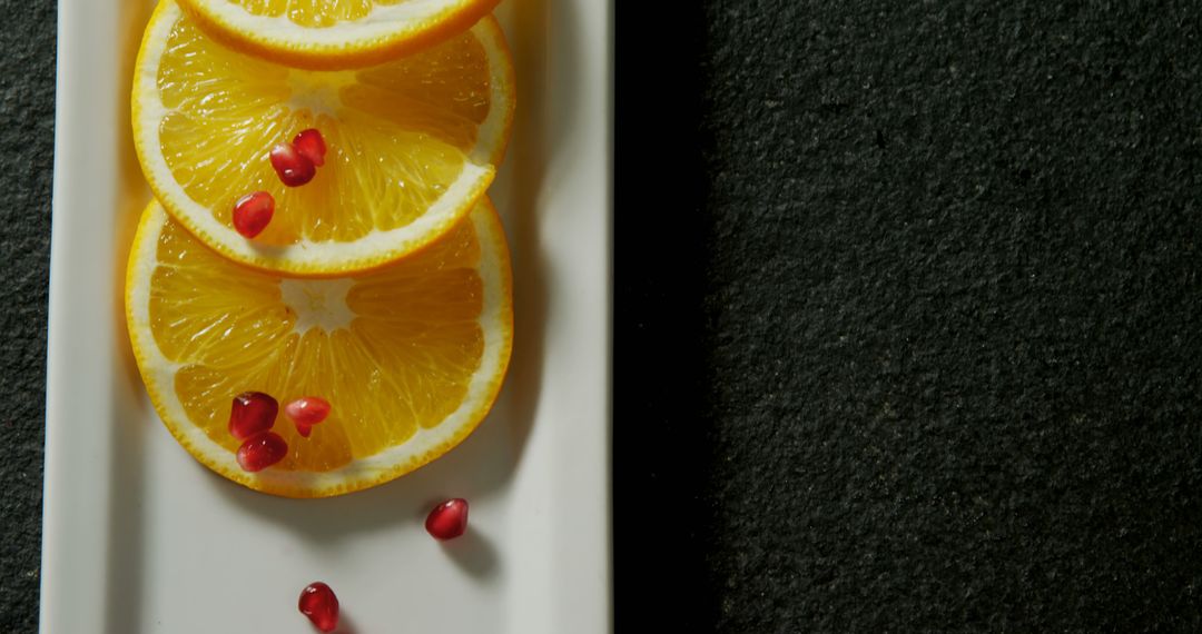 Sliced Oranges with Pomegranate Seeds on White Tray - Free Images, Stock Photos and Pictures on Pikwizard.com