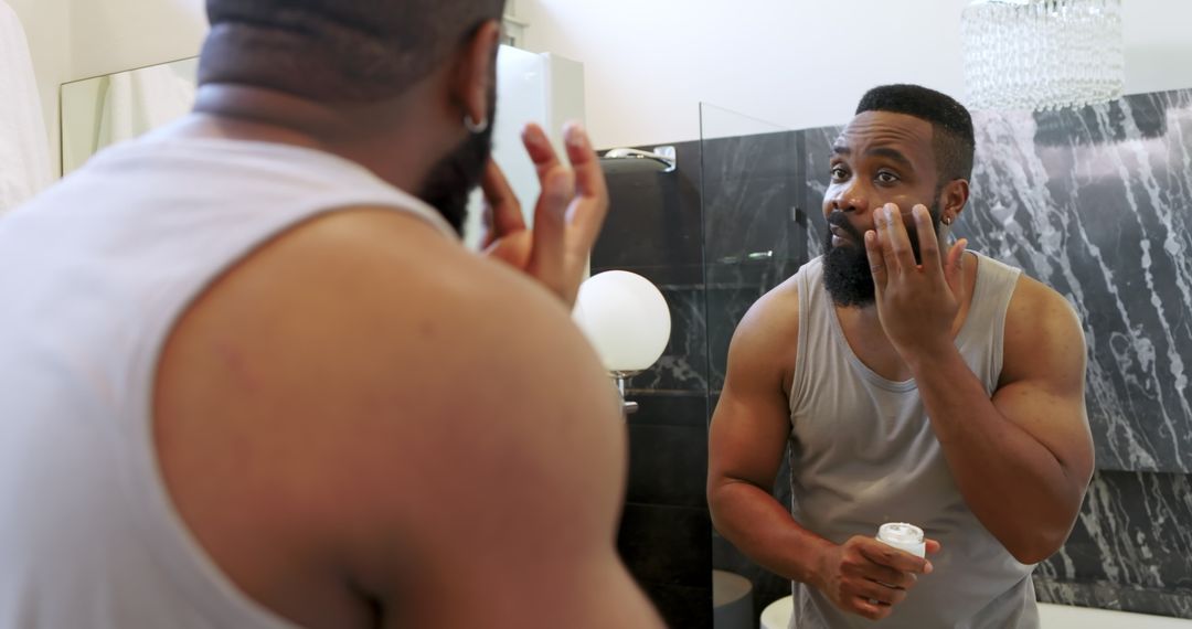 Man Applying Facial Cream in Bathroom for Skincare Routine