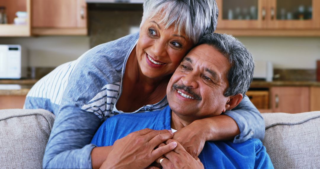 Happy Senior Couple Embracing on Couch at Home - Free Images, Stock Photos and Pictures on Pikwizard.com