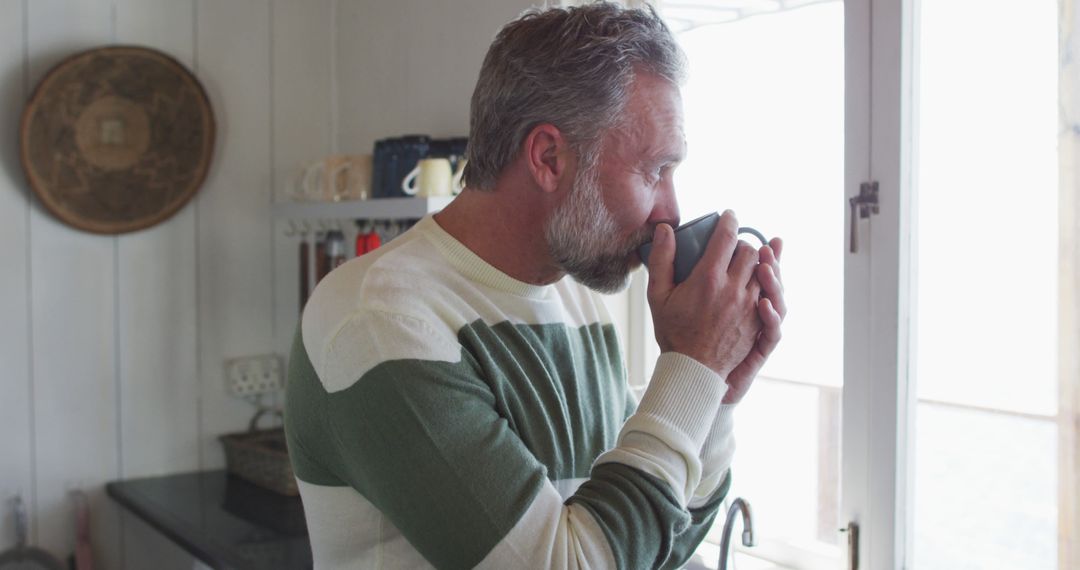 Senior man enjoying morning coffee by the window - Free Images, Stock Photos and Pictures on Pikwizard.com