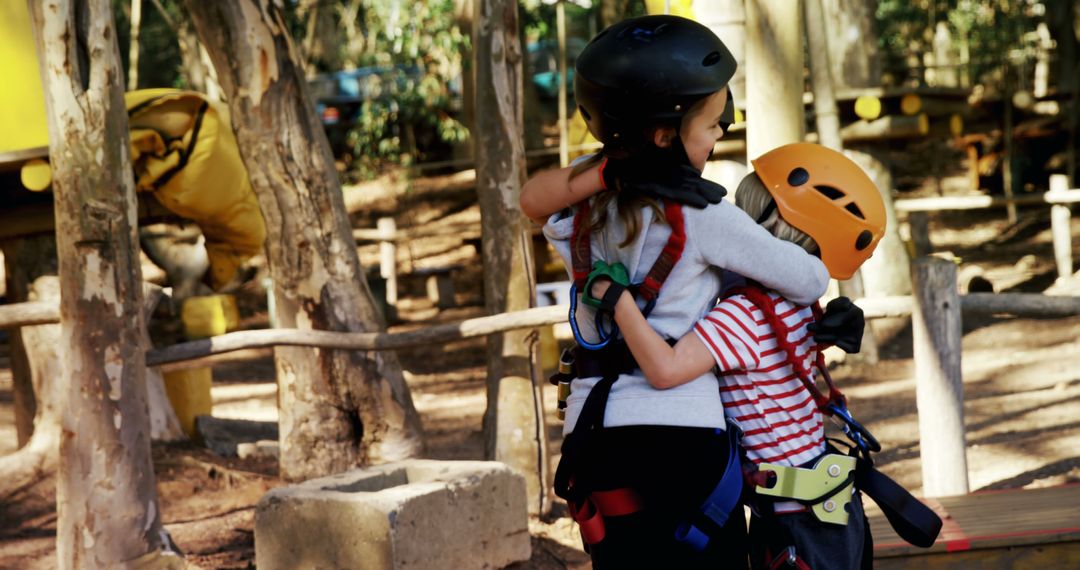 Children Hugging with Joy at Adventure Park in Safety Gear