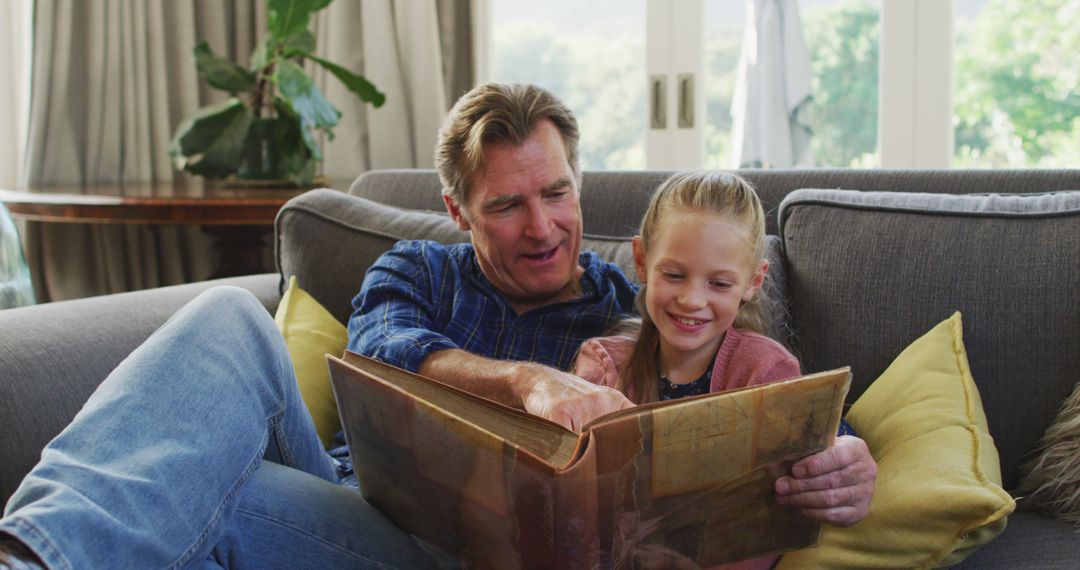 Grandfather and Granddaughter Reading Picture Book Together at Home - Free Images, Stock Photos and Pictures on Pikwizard.com