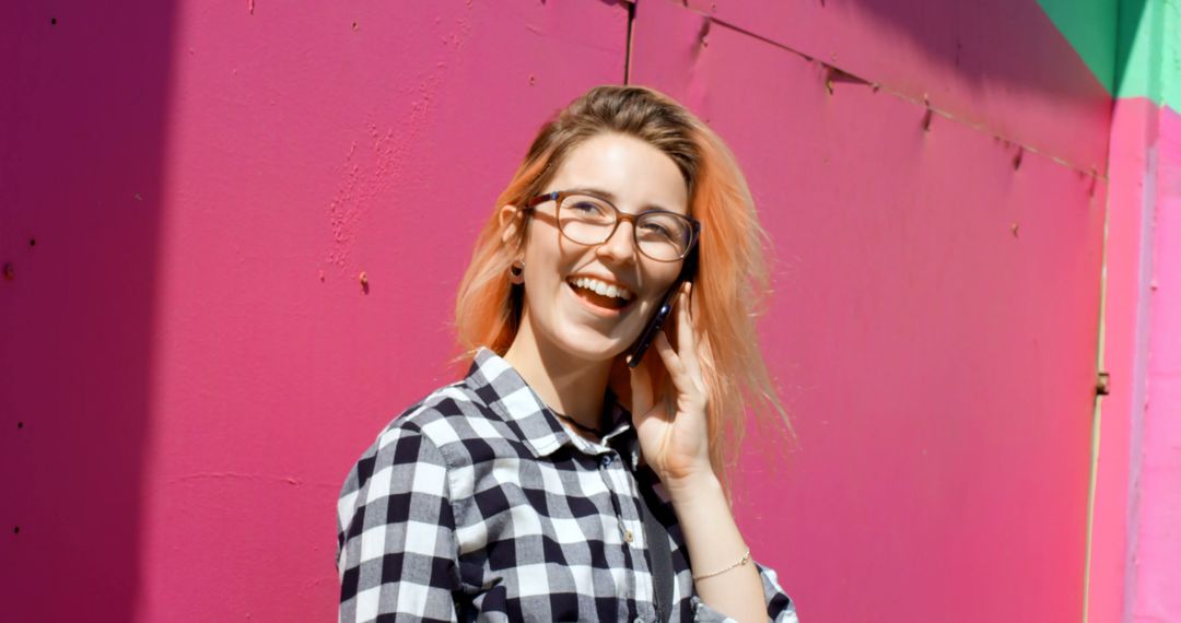 Smiling Young Woman Talking on Phone Against Pink Wall - Free Images, Stock Photos and Pictures on Pikwizard.com