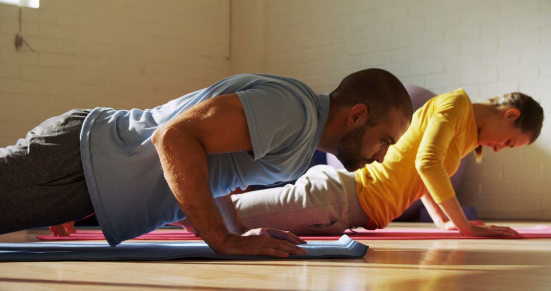 Focused Couple Practicing Yoga in Sunlit Studio - Free Images, Stock Photos and Pictures on Pikwizard.com