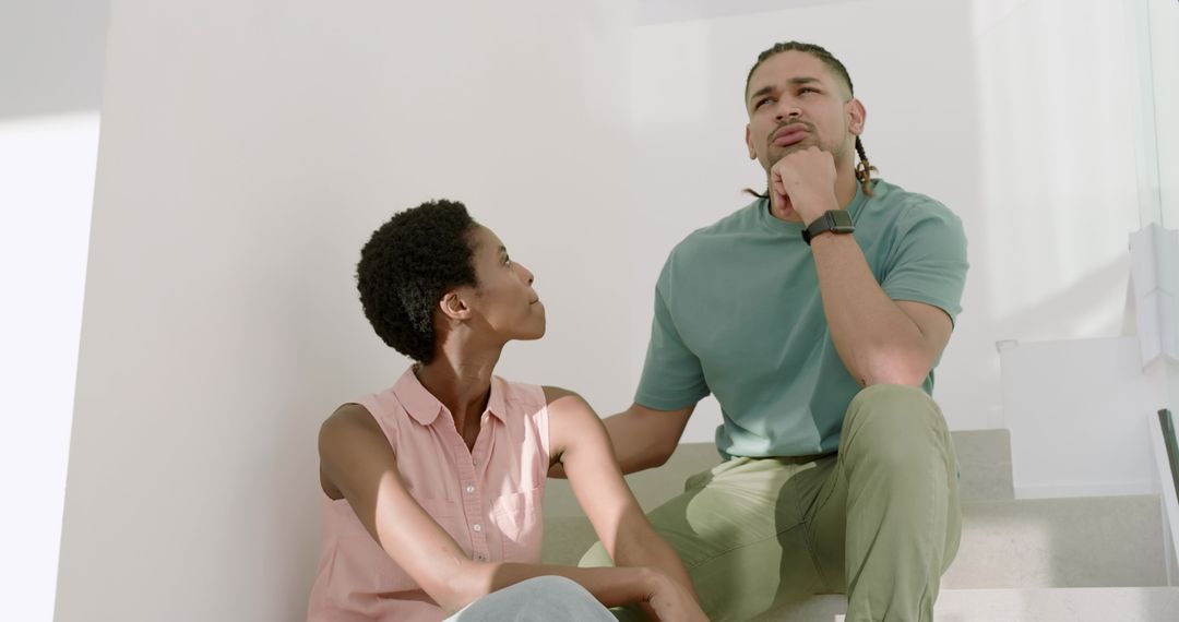 Contemplative Couple Sitting on Modern Home Stairs