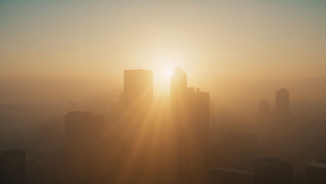 Sunrise Over Cityscape with Skyscraper Silhouettes in Golden Light