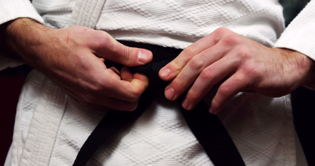 Martial Artist Tying Black Belt in Traditional Gi - Free Images, Stock Photos and Pictures on Pikwizard.com