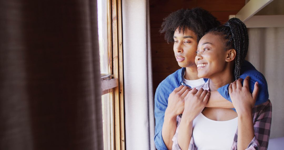 Affectionate Couple Gazing Out Rustic Cabin Window