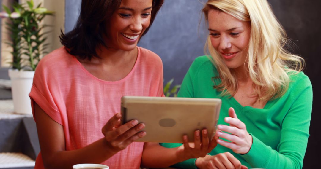 Two Women Enjoying Digital Content Together on a Tablet - Free Images, Stock Photos and Pictures on Pikwizard.com