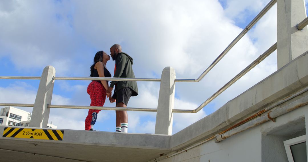 Couple Kissing on Elevated Platform Against Blue Sky - Free Images, Stock Photos and Pictures on Pikwizard.com