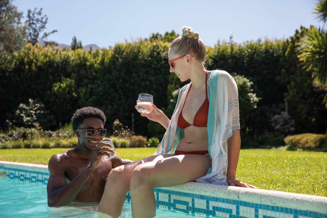 Couple Enjoying Refreshing Drinks by Poolside in Luxury Resort Garden